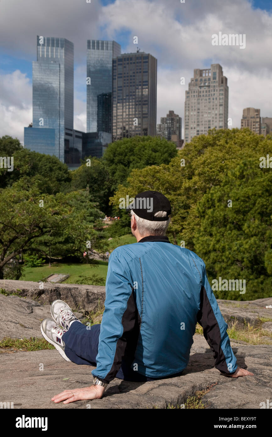 Uomo in Central Park e New York skyline della città Foto Stock