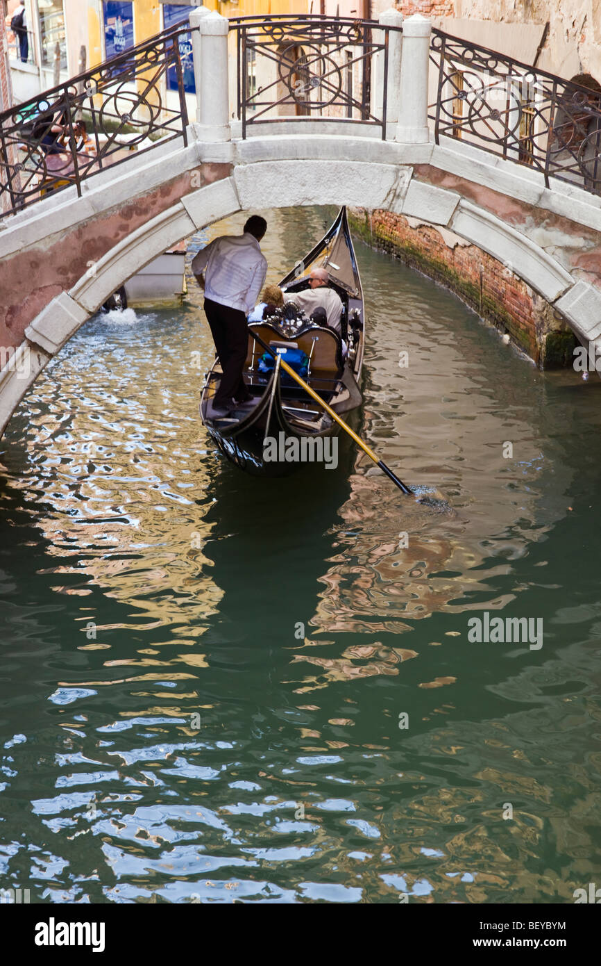 Gondola passando sotto un ponte, Venezia, Italia Foto Stock