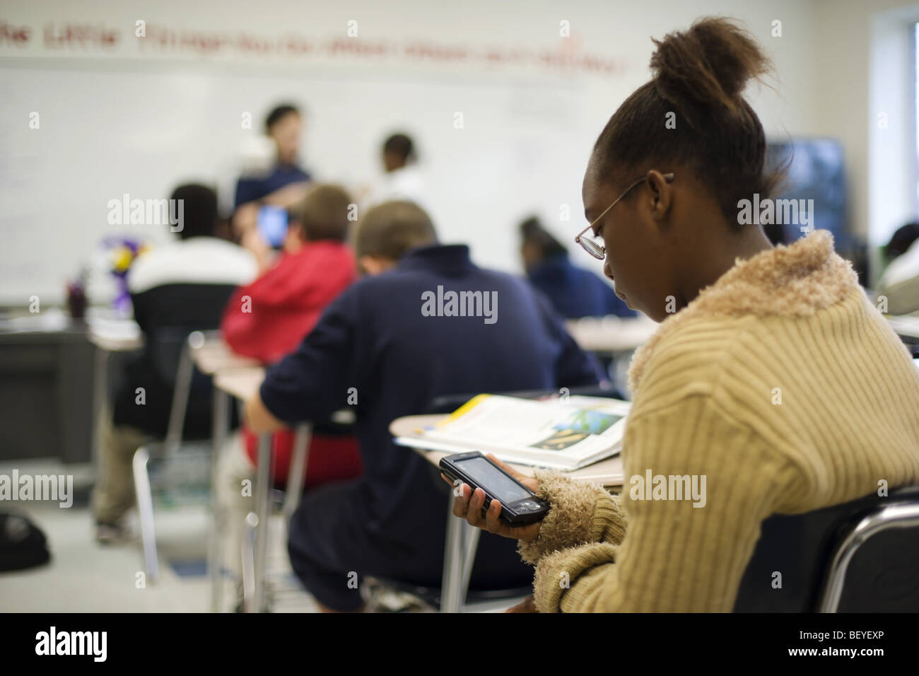 Multi etnico gruppo di studenti in aula con Palm del computer e insegnante femmina, Foto Stock