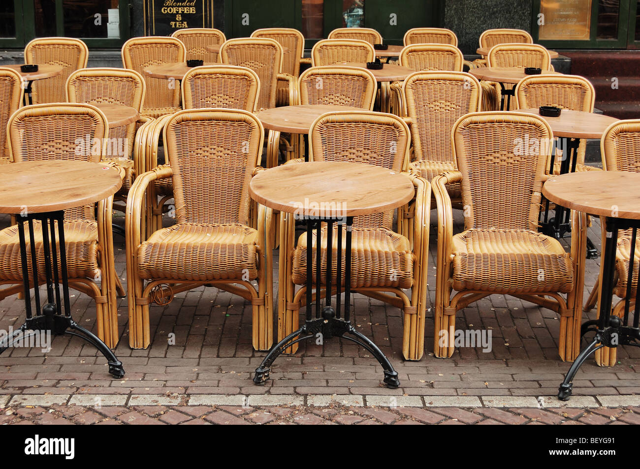 Vuoto tavoli da pranzo e sedie di rattan in una street café, Amsterdam Foto Stock