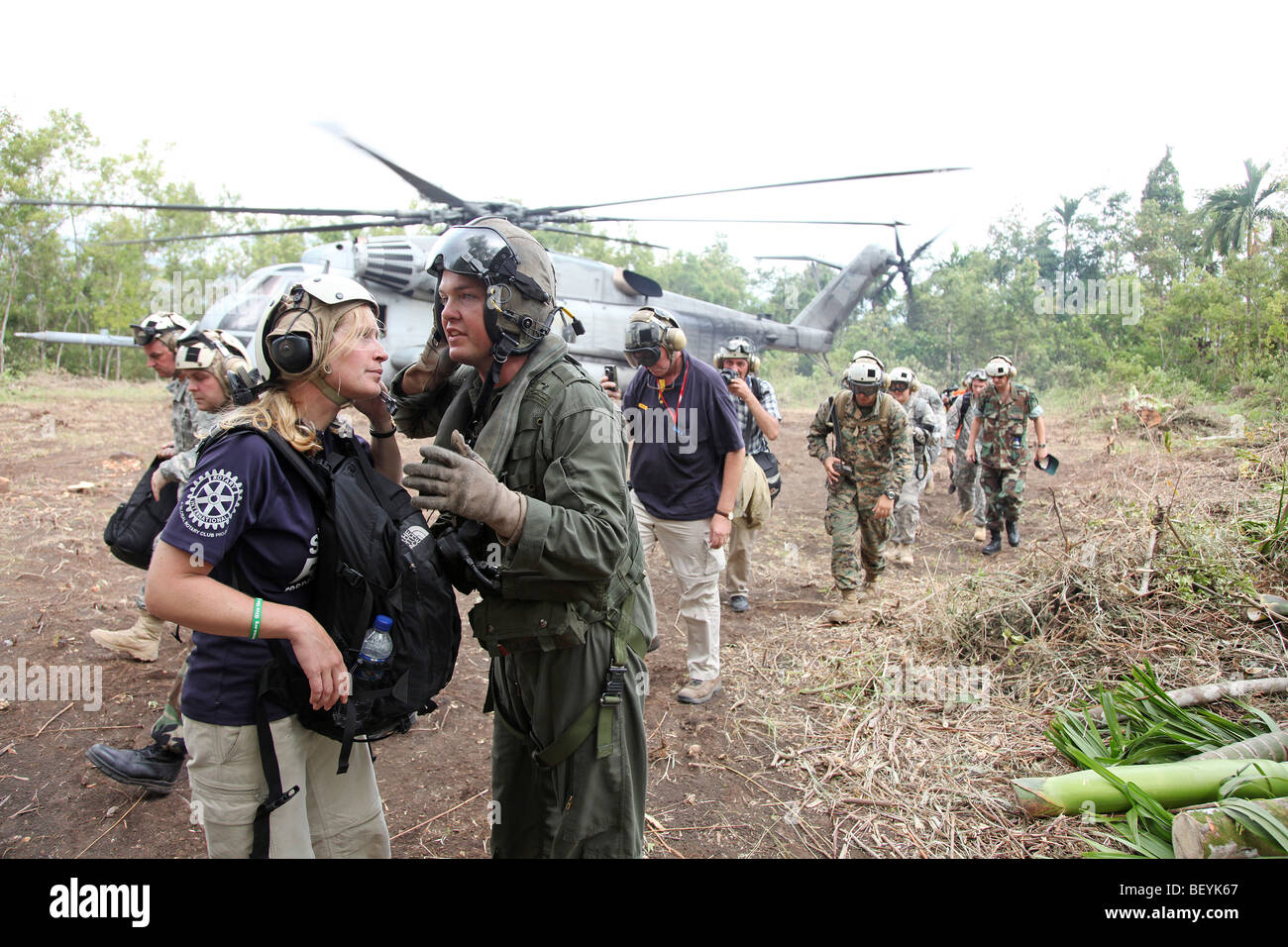 Noi pilota di elicottero colloqui con lavoratore ONG a HLZ in Hulu Banda, Agam, a ovest di Sumatra, Indonesia Foto Stock