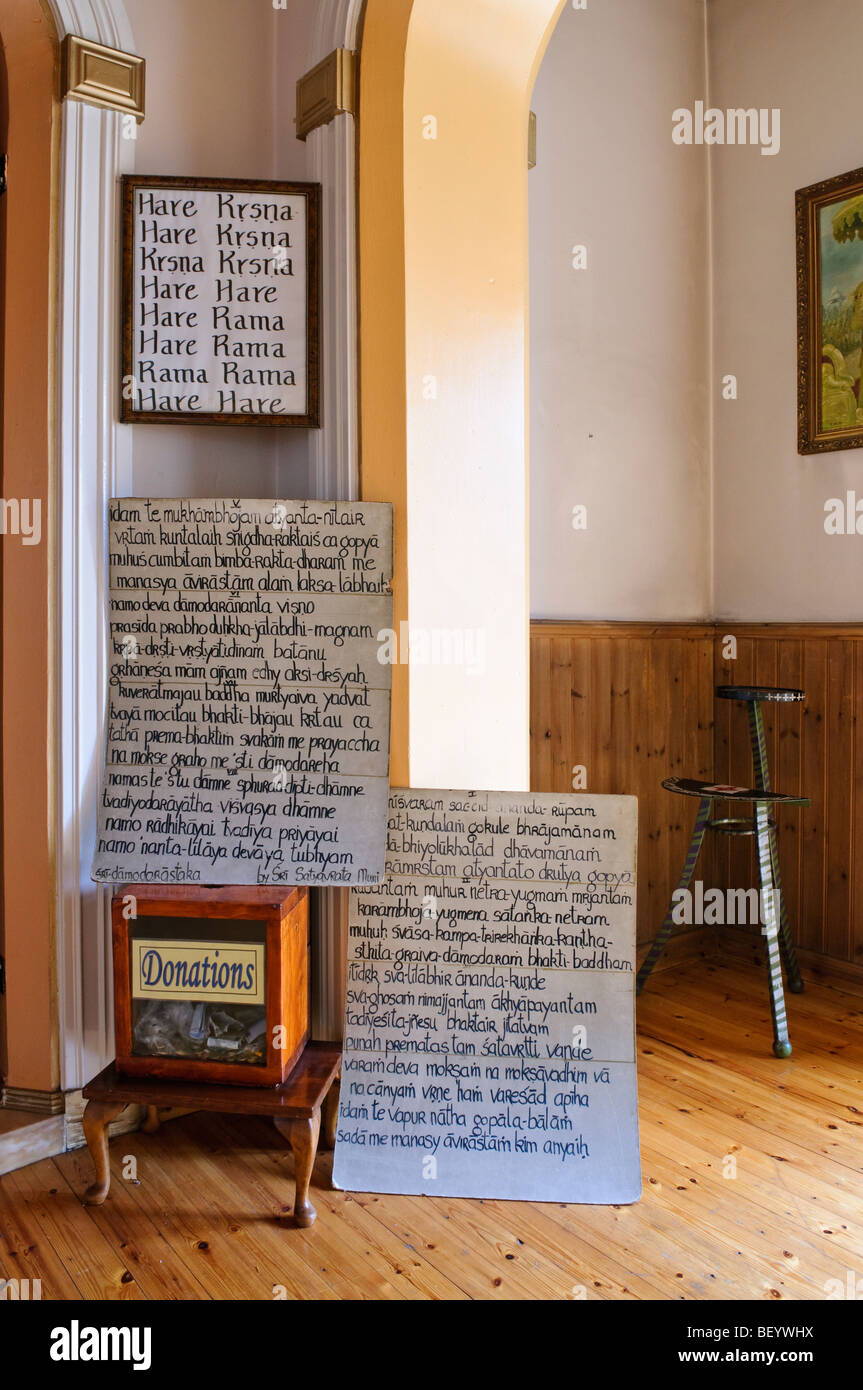 Il sanscrito segni in un Hare Krishna temple camera, accanto a una scatola per le donazioni Foto Stock