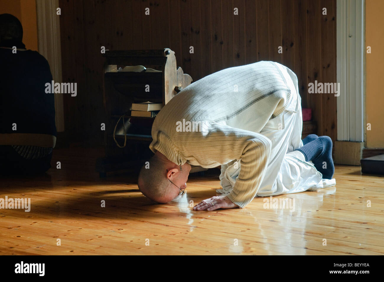 Hare Krishna devoto archi toccando il suo fronte al pavimento Foto Stock