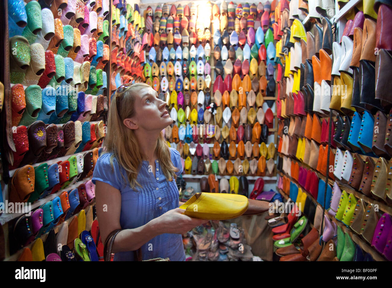 Una donna acquisto shous al souk di Marrakech shop, Marocco Foto Stock