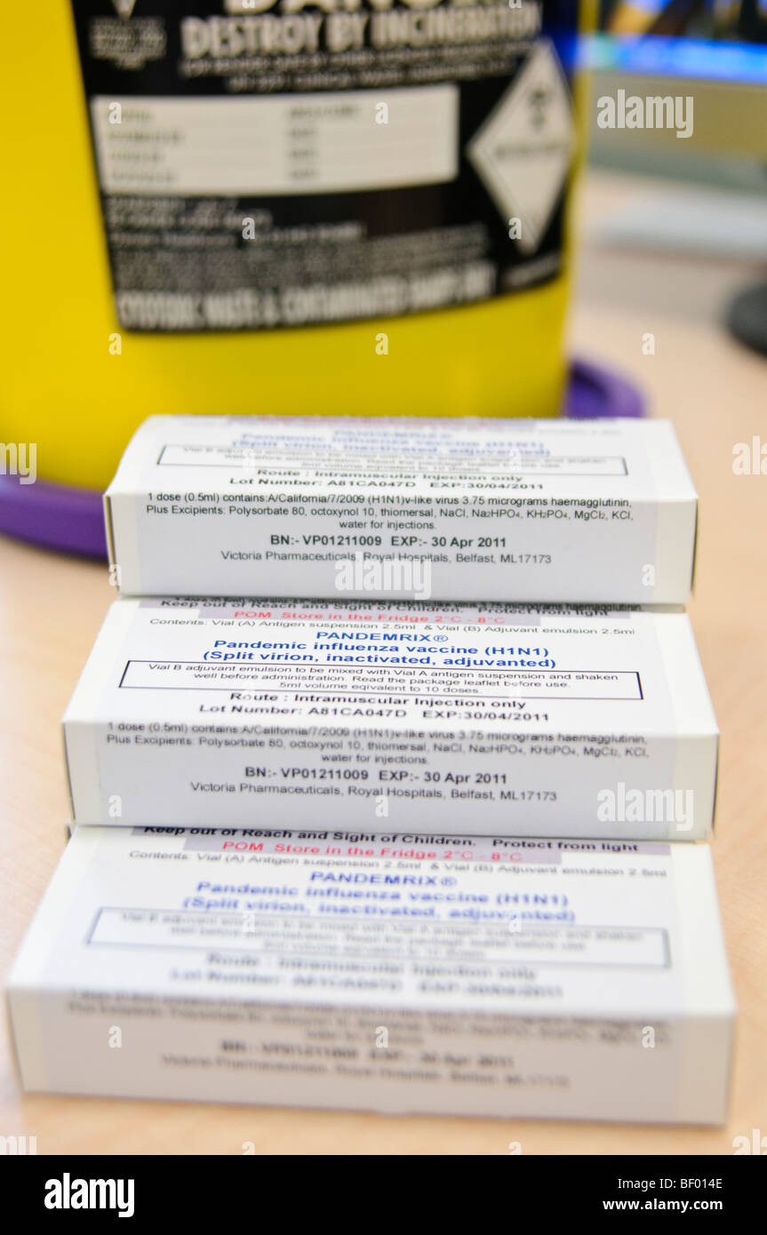 Scatole di Pandemrix, GlaxoSmithKline influenza suina vaccino su una tabella in un GP Chirurgia accanto a un Sharpsafe. Foto Stock
