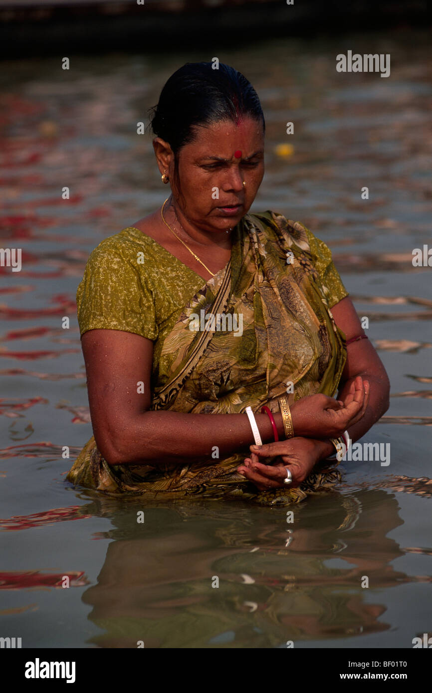 India, Uttar Pradesh, Allahabad, Sangam, donna che fa il bagno alla confluenza dei fiumi Gange e Yamuna Foto Stock