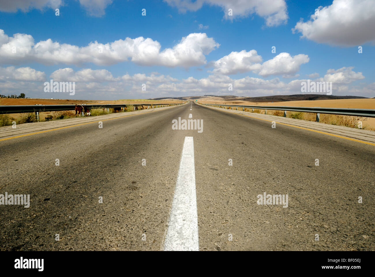 Australian, western New South Wales, infinite Road to Nowhere acceso all'orizzonte il cielo blu con nuvole Foto Stock
