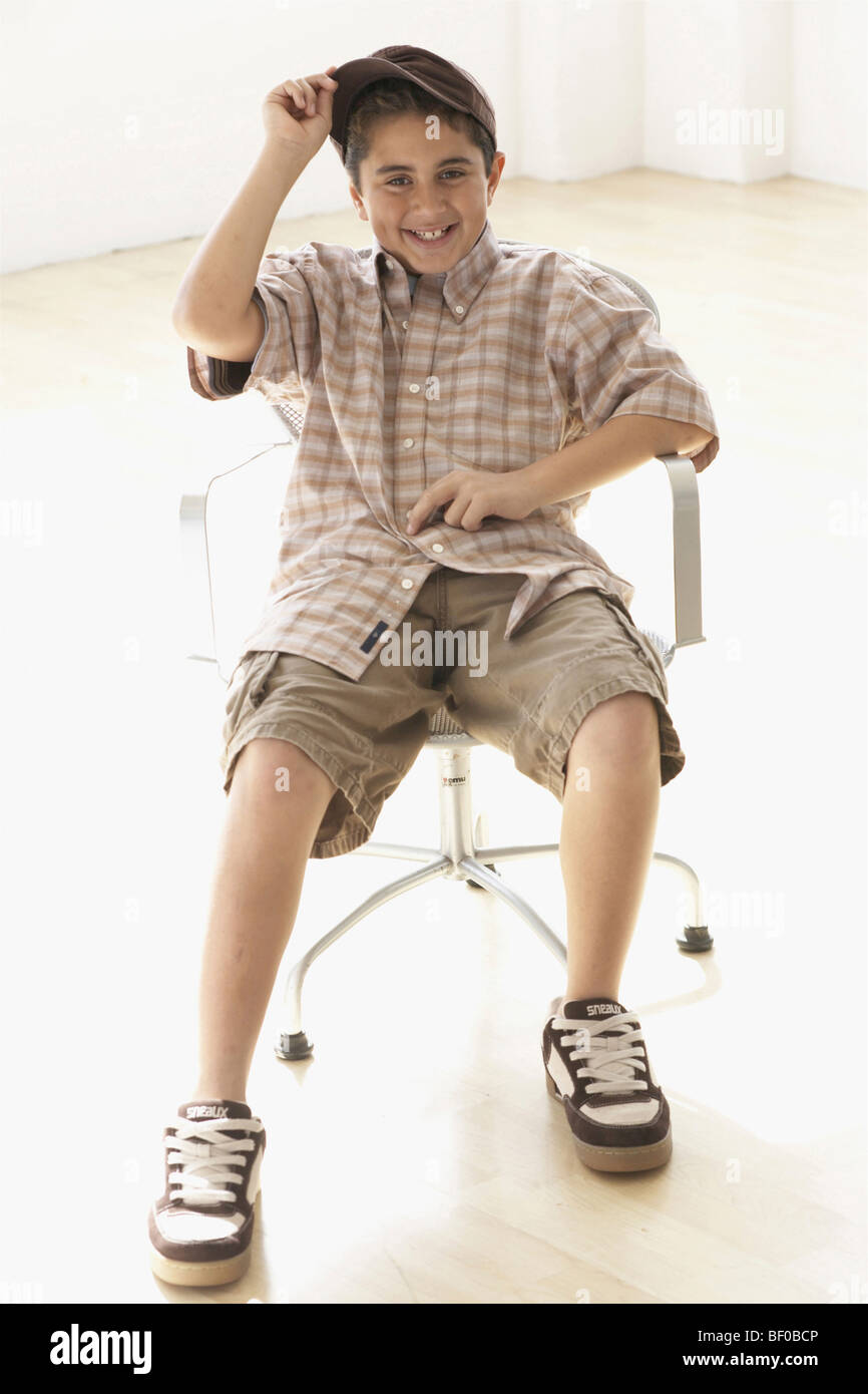 Ritratto di un ragazzo seduto in poltrona Foto Stock
