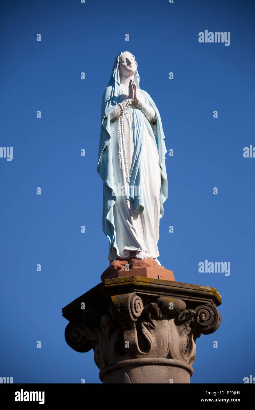 Vergine Maria statua in preghiera. Alsace Francia. Blue sky 099607 Alsazia Foto Stock