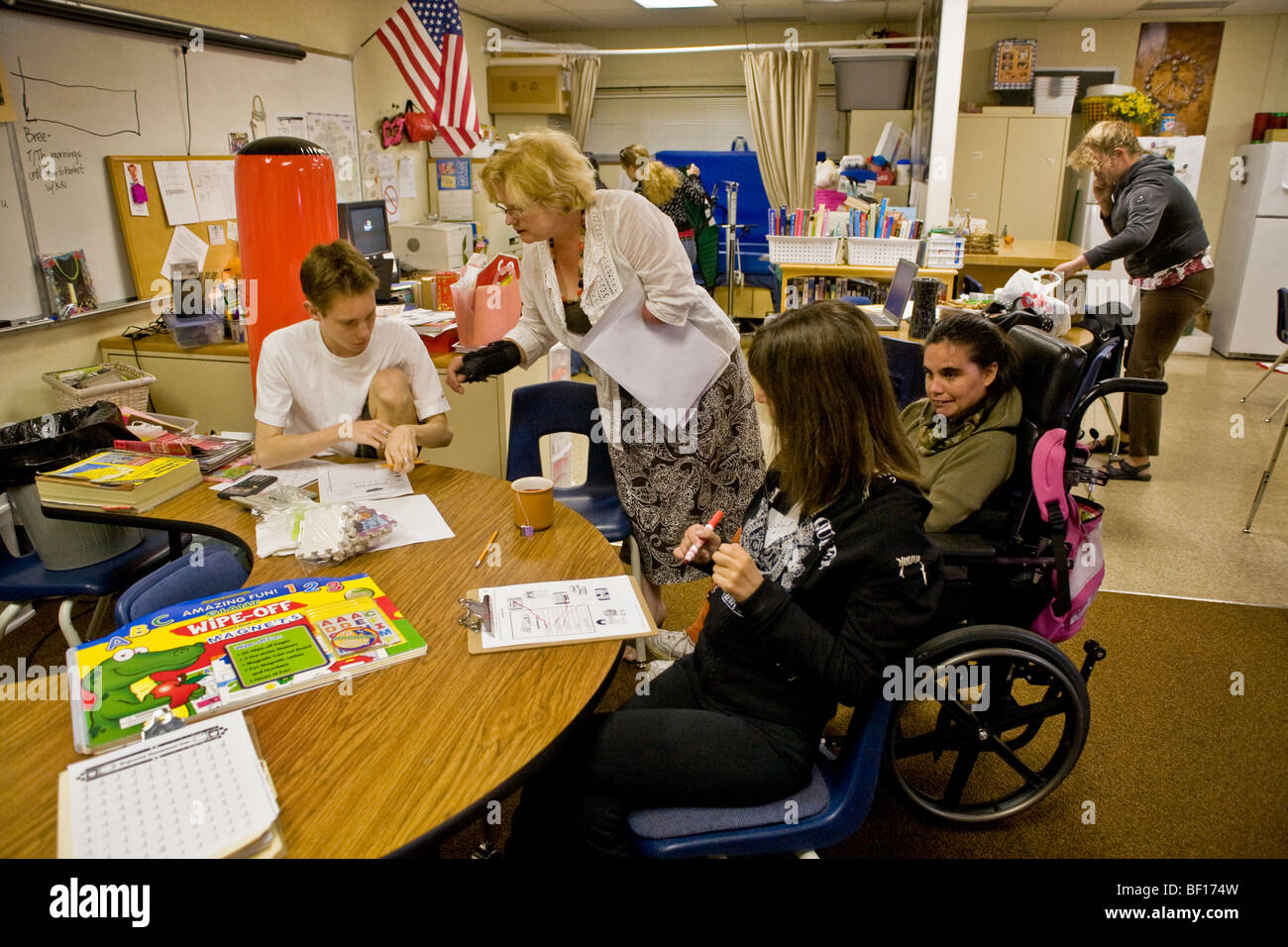 Un centro di età appositamente formati maestro che è essa stessa handicappati lavora con gli studenti portatori di handicap presso una scuola della California Foto Stock