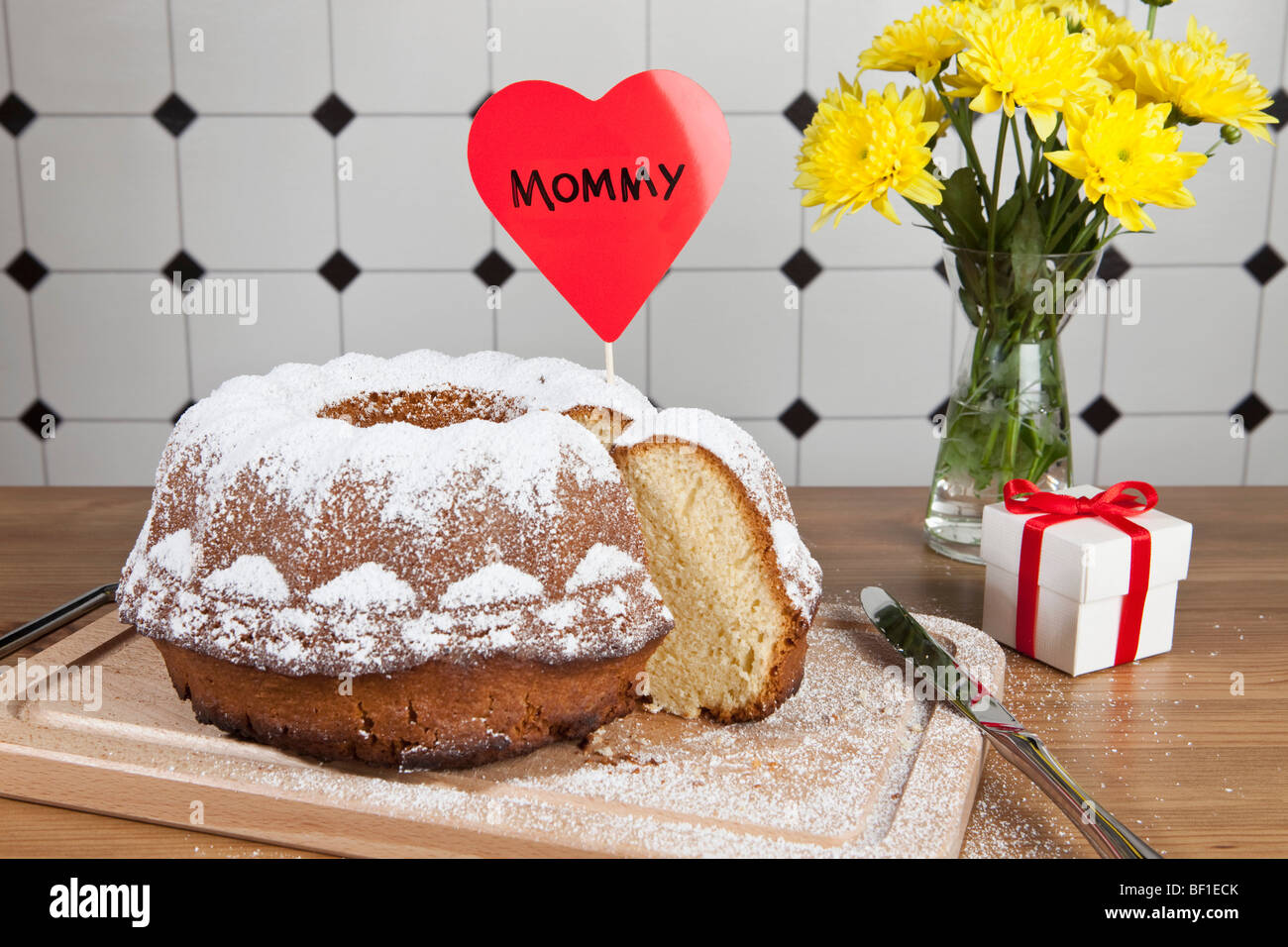 Una torta di Bundt, fiori e un regalo per la Festa della mamma Foto Stock