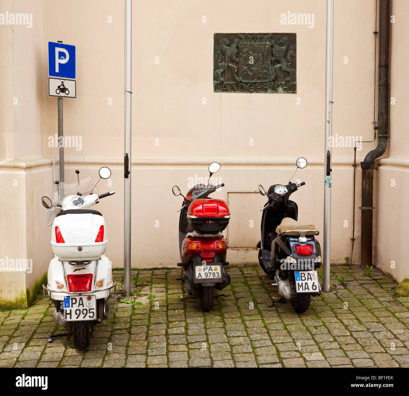 Tre scooter parcheggiato in un parcheggio scooter zona su una vecchia strada in Germania Europa Foto Stock