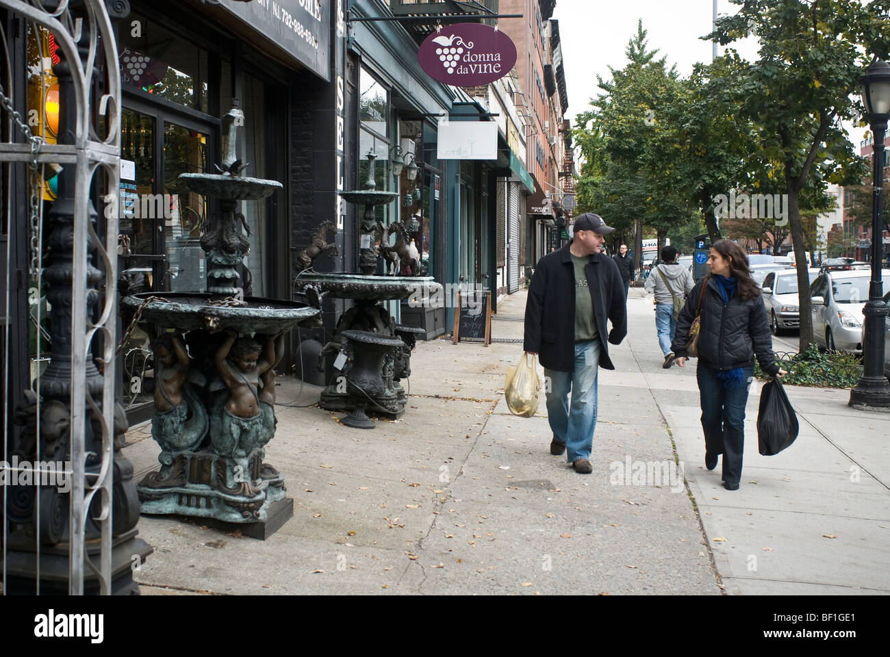 Un giovane passa un commerciante d'antiquariato su Atlantic Avenue in Boerum Hill quartiere di Brooklyn a New York Foto Stock