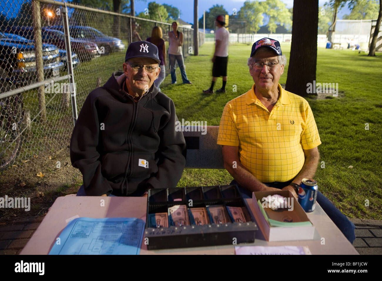 Gli uomini raccolgono ammissione di notte di baseball gioco in cascata, Iowa Foto Stock