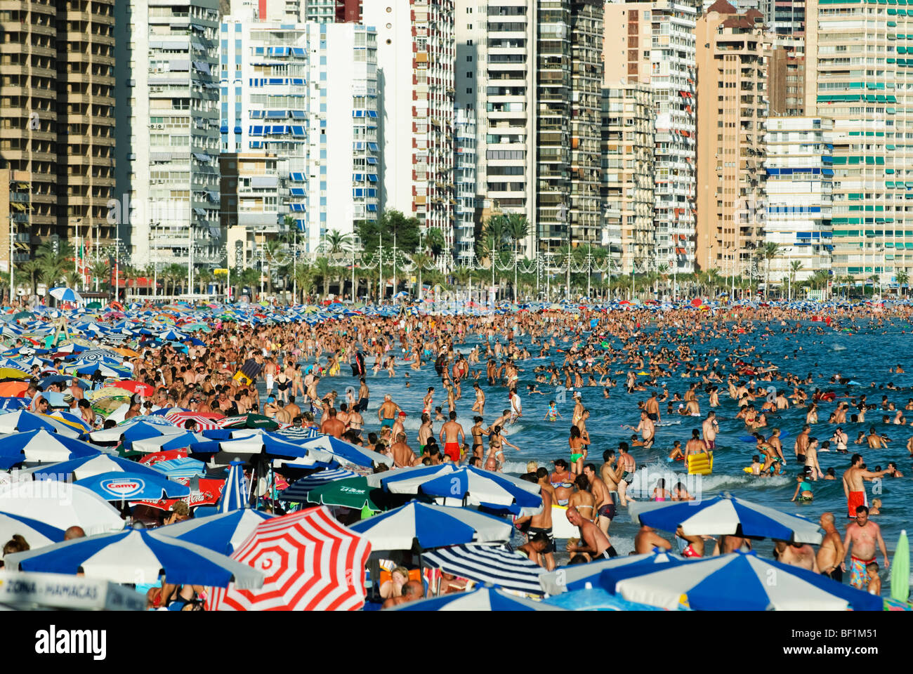 I turisti affollano Playa Playa de Levante di Benidorm, Costa Blanca, Spagna, durante il periodo di alta stagione Foto Stock