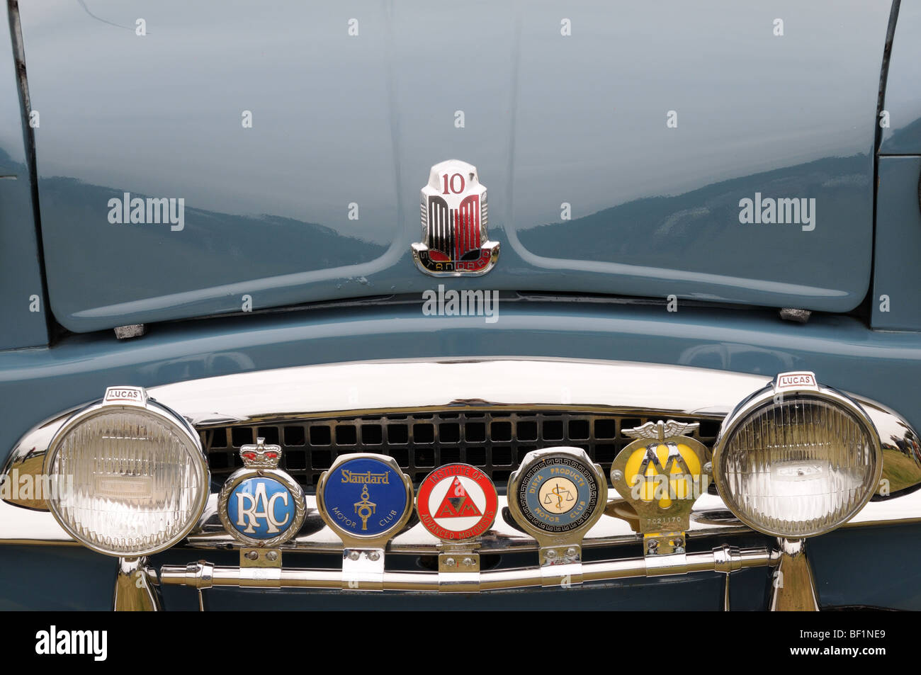 Una collezione di badge vettura sulla griglia di un trionfo Standard 10 classic car Foto Stock