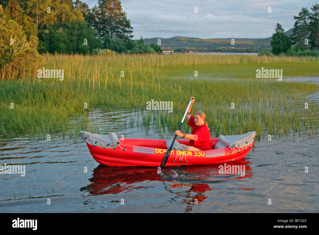 Giovane donna in una gomma barca sul lago Siljan vicino Utanmyra, Svezia e Scandinavia Foto Stock