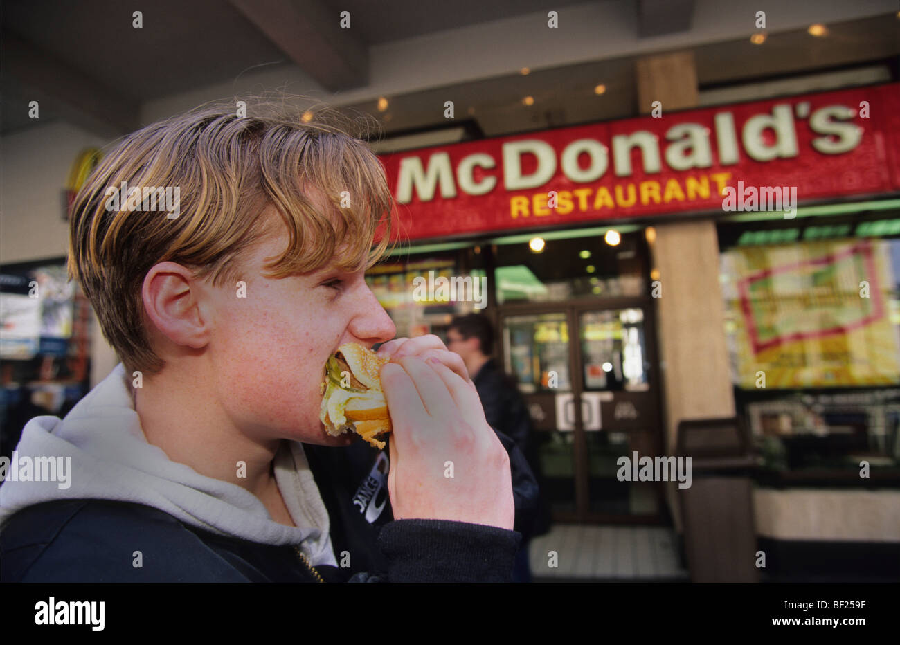 La gioventù di mangiare hamburger fuori ristorante Macdonalds, Birmingham, Inghilterra Foto Stock
