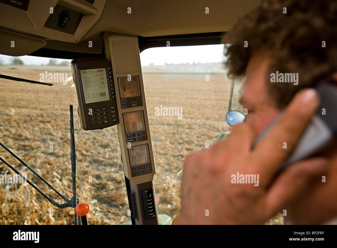 Interno di una mietitrebbia durante la mietitura di granoturco che mostra il monitor di controllo della resa e di combinare vari indicatori di funzionamento / Minnesota, Stati Uniti d'America. Foto Stock