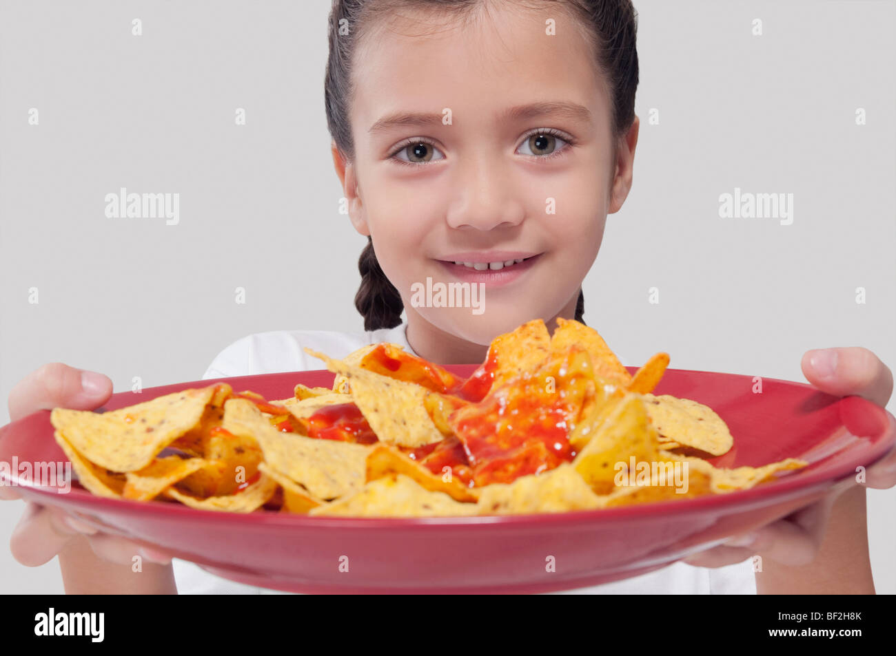 Ritratto di una ragazza con un piatto di nachos Foto Stock