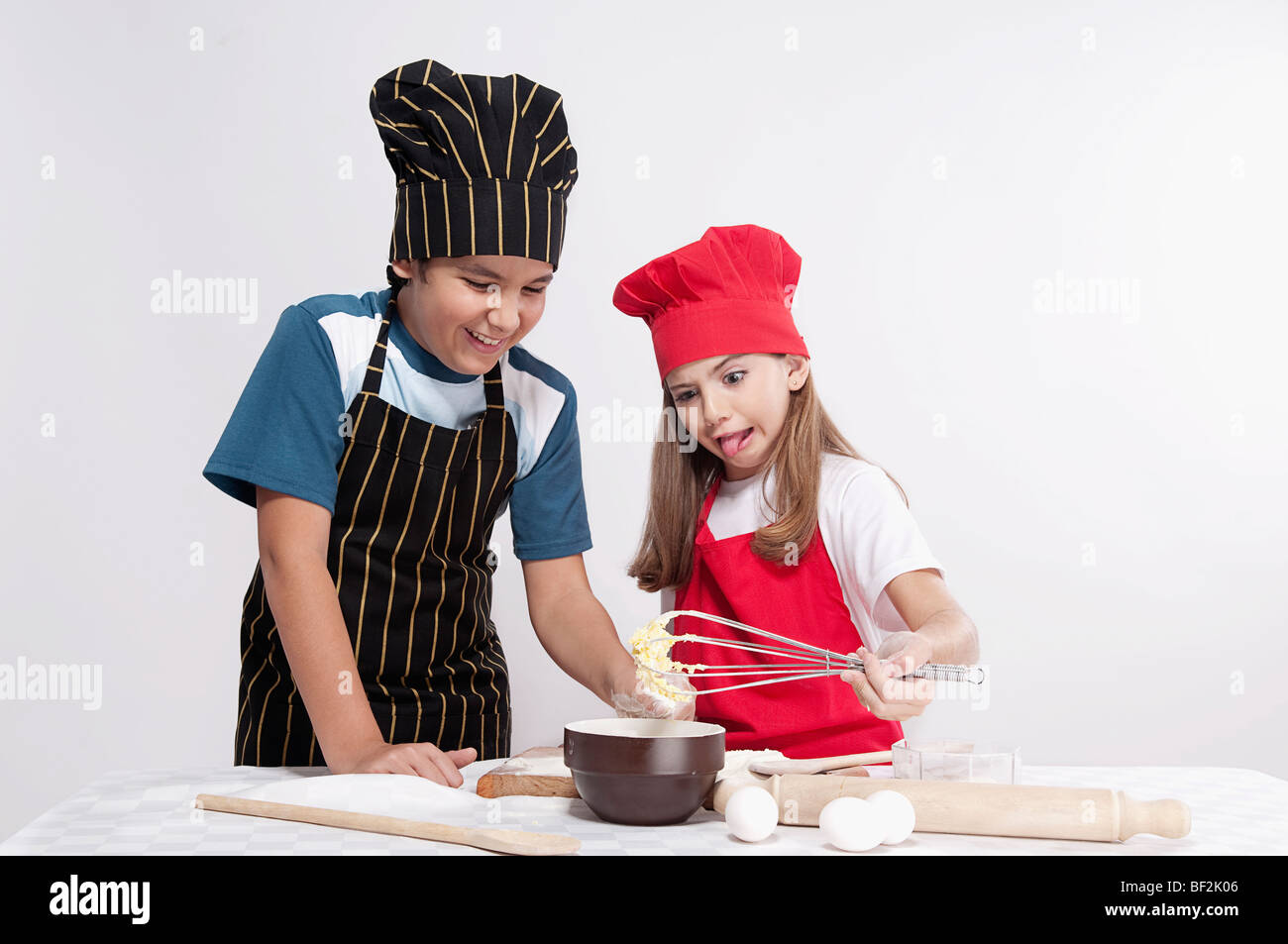 Ragazzo che guarda alla pastella mantecato con sua sorella Foto Stock