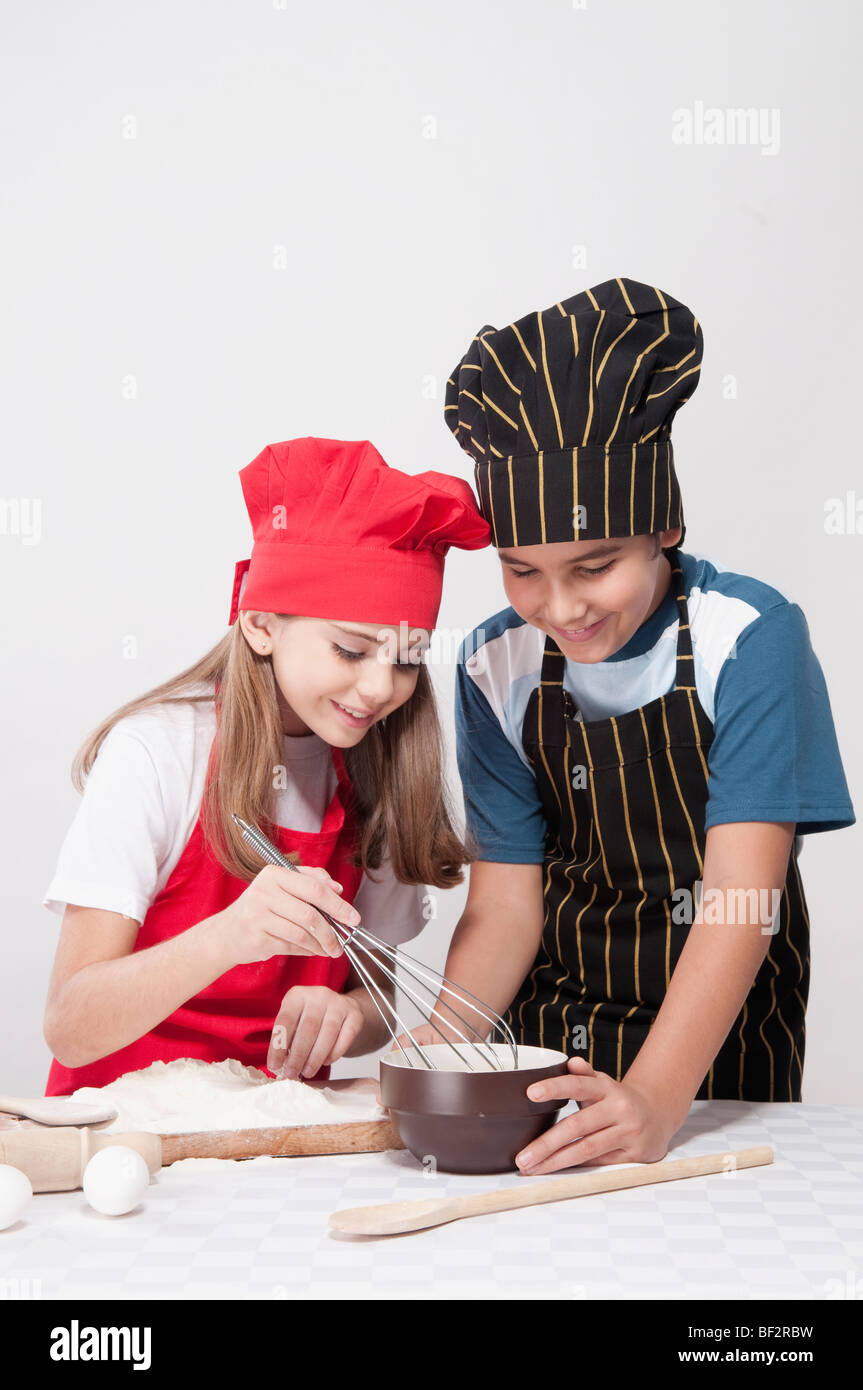 Ragazzo preparare una torta con sua sorella Foto Stock