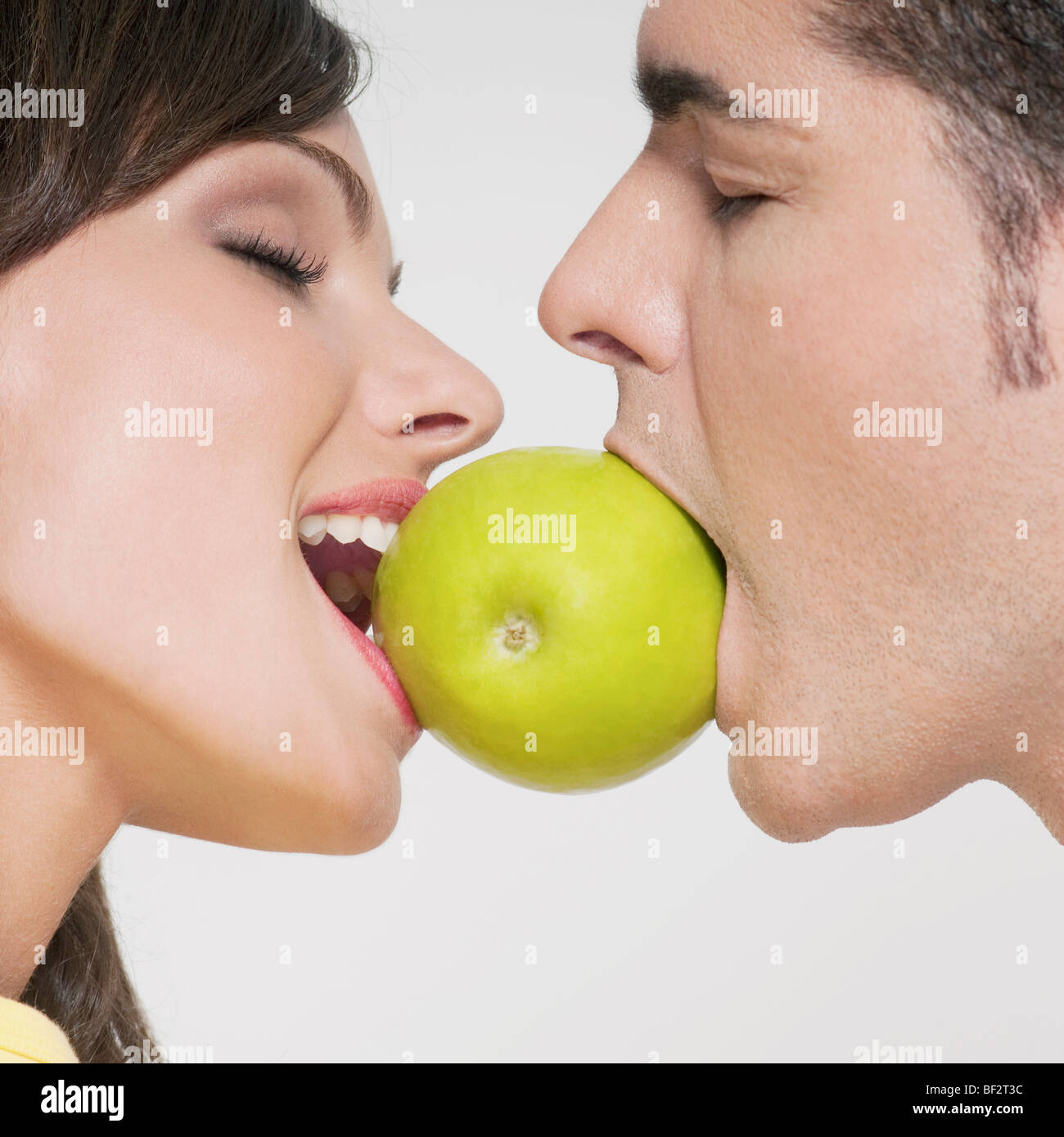 Paio di mordere in una mela verde Foto Stock