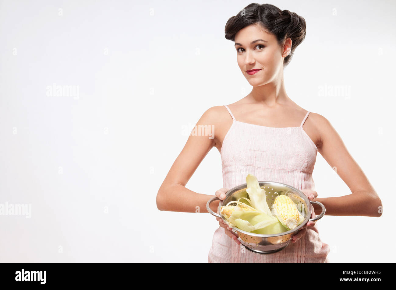 Donna che mantiene i tutoli in uno scolapasta Foto Stock