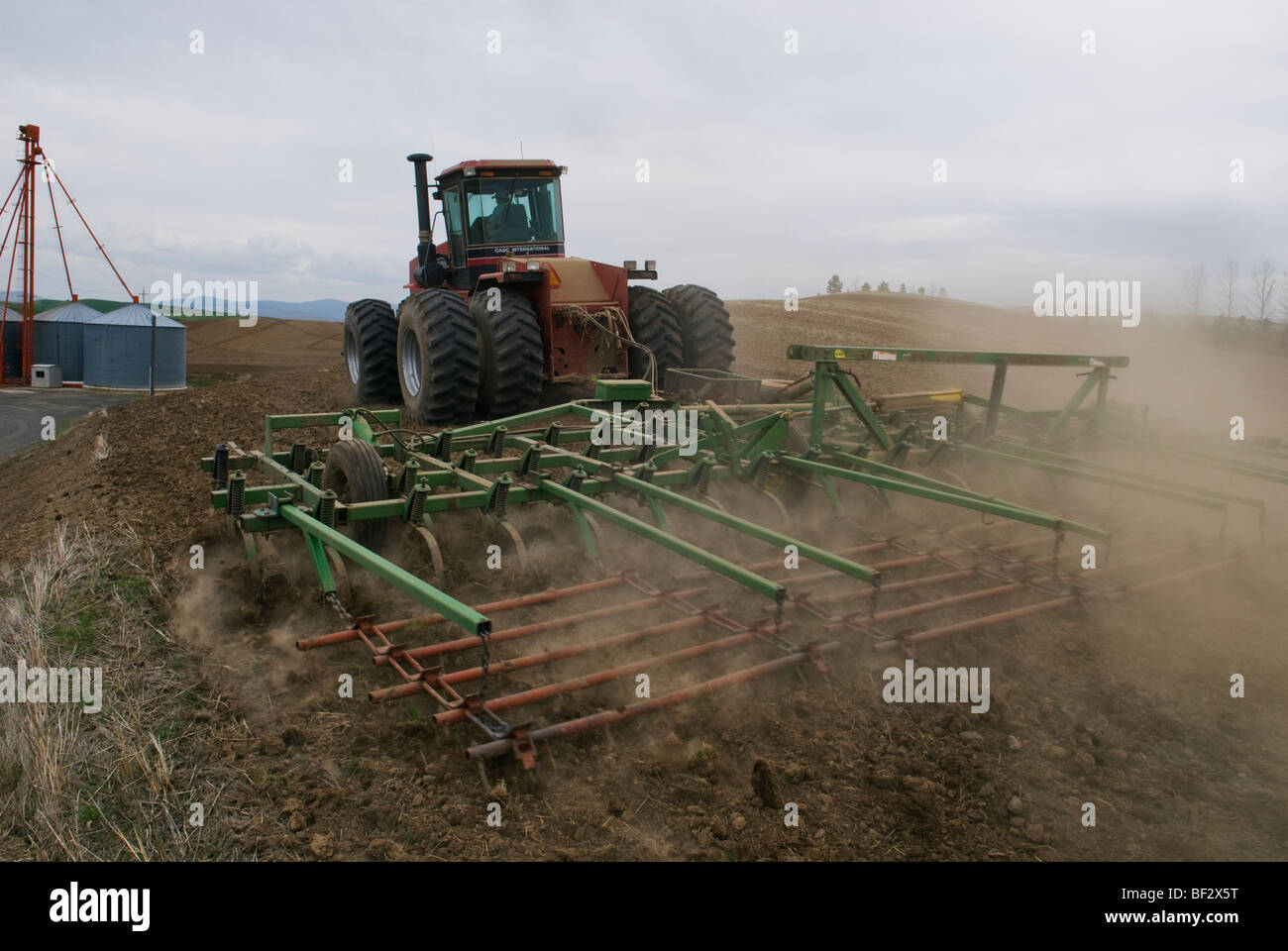 Un trattore coltivatore e la preparazione di un campo per la semina Ceci / vicino al Pullman, Regione Palouse, Washington, Stati Uniti d'America. Foto Stock