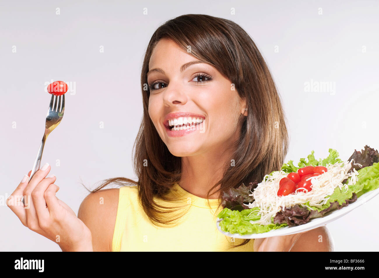 Ritratto di una donna di mangiare insalata Foto Stock