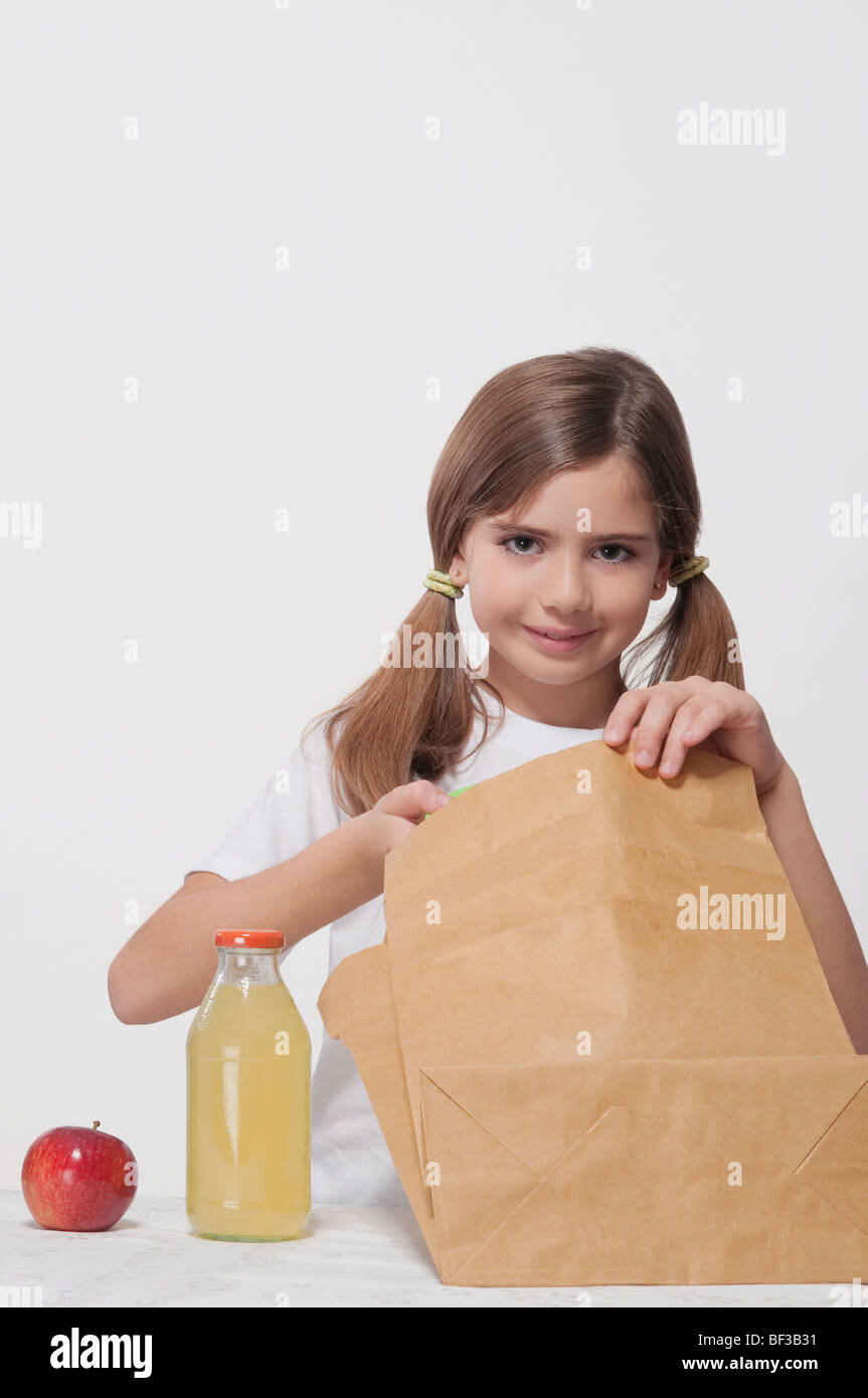 Ritratto di una ragazza di imballaggio per il pranzo a scuola Foto Stock