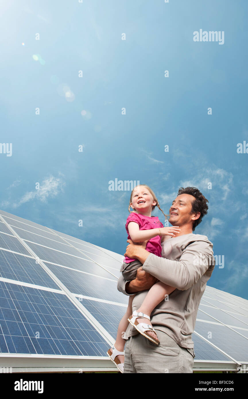 L uomo e la figlia nella parte anteriore del pannello solare Foto Stock