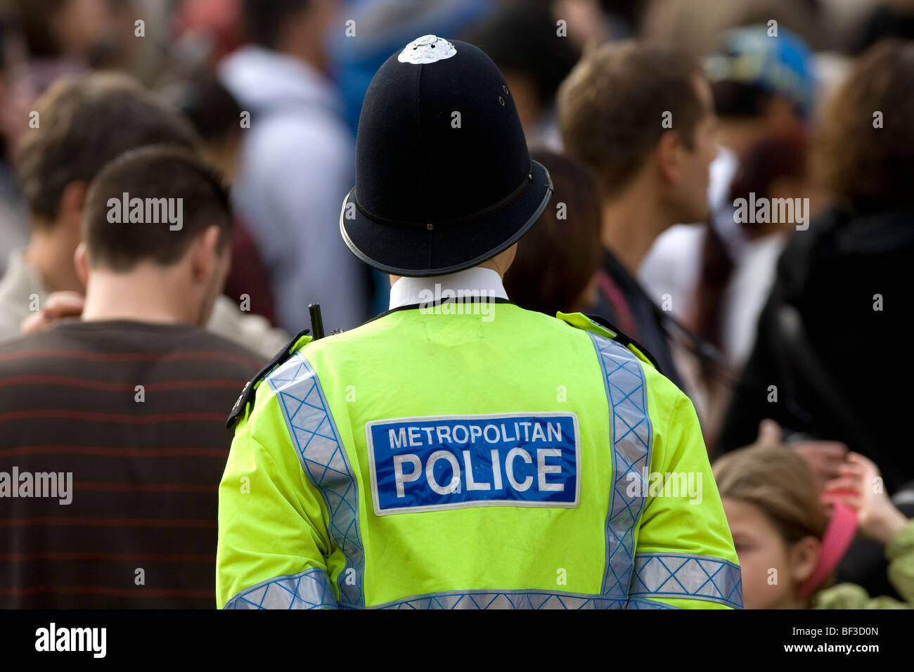 Un London Metropolitan poliziotto in una elevata visibilità giacca gialla e casco sul dovere Foto Stock