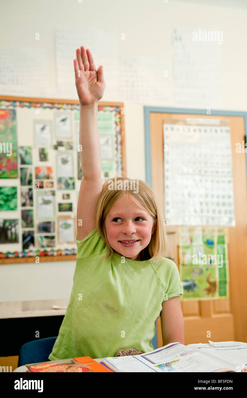Scuola elementare studente alzando la mano Foto Stock