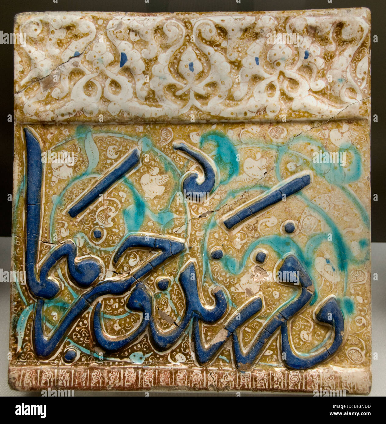 Antica piastrella di fregio in ceramica smaltata persiana con calligrafia Thuluth modellata in blu cobalto su sfondo dorato lustrante, periodo Ilkhanide 13° secolo fro Foto Stock