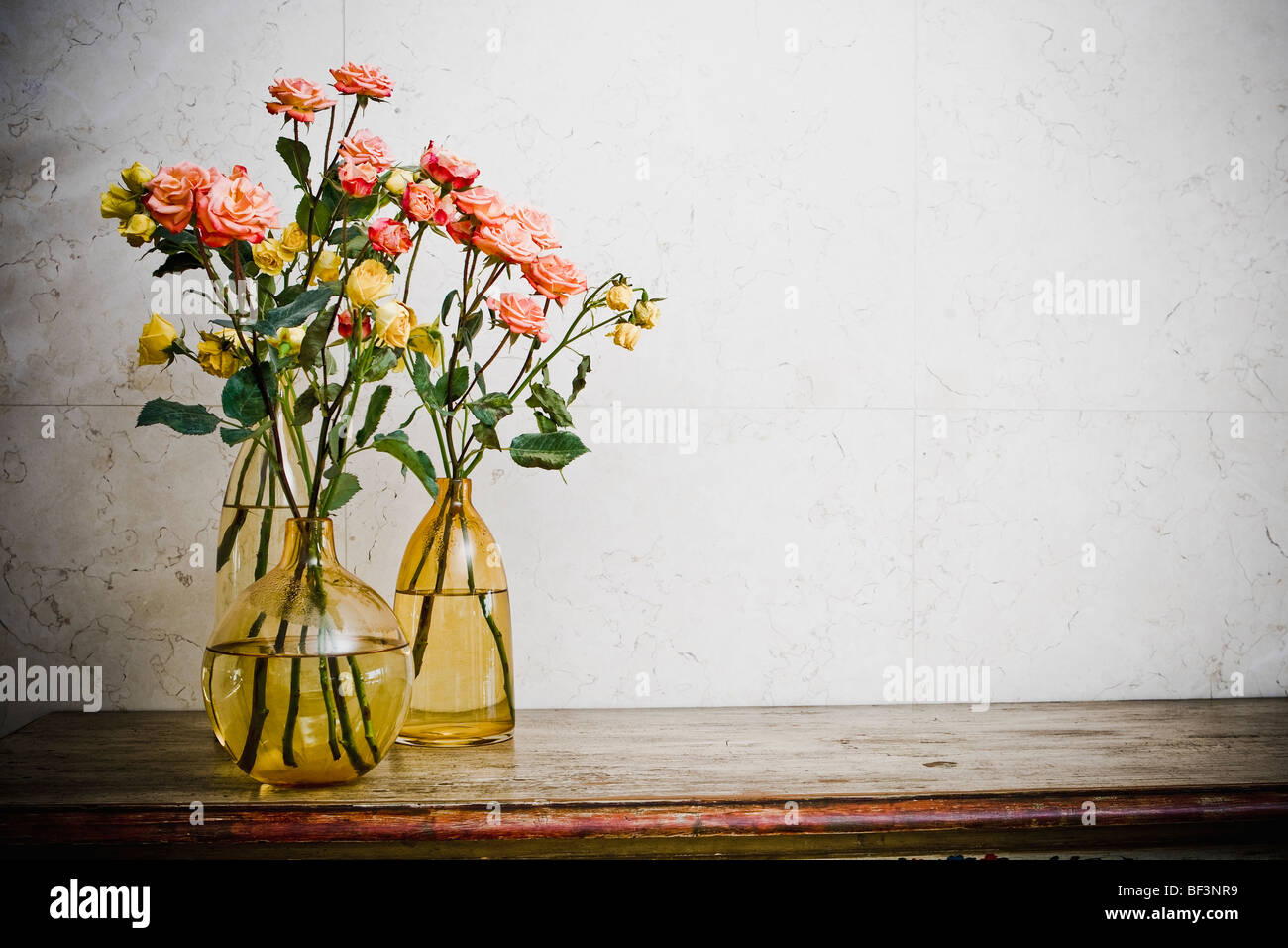 Vasi di fiori con rose fiori su una credenza Foto Stock