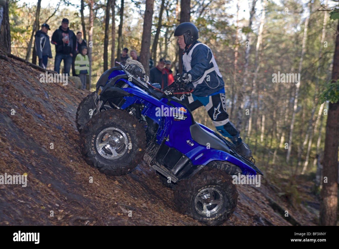 L'uomo corse fuoristrada (ATV) su terreno ripido nel bosco. Trial off-road bike Foto Stock