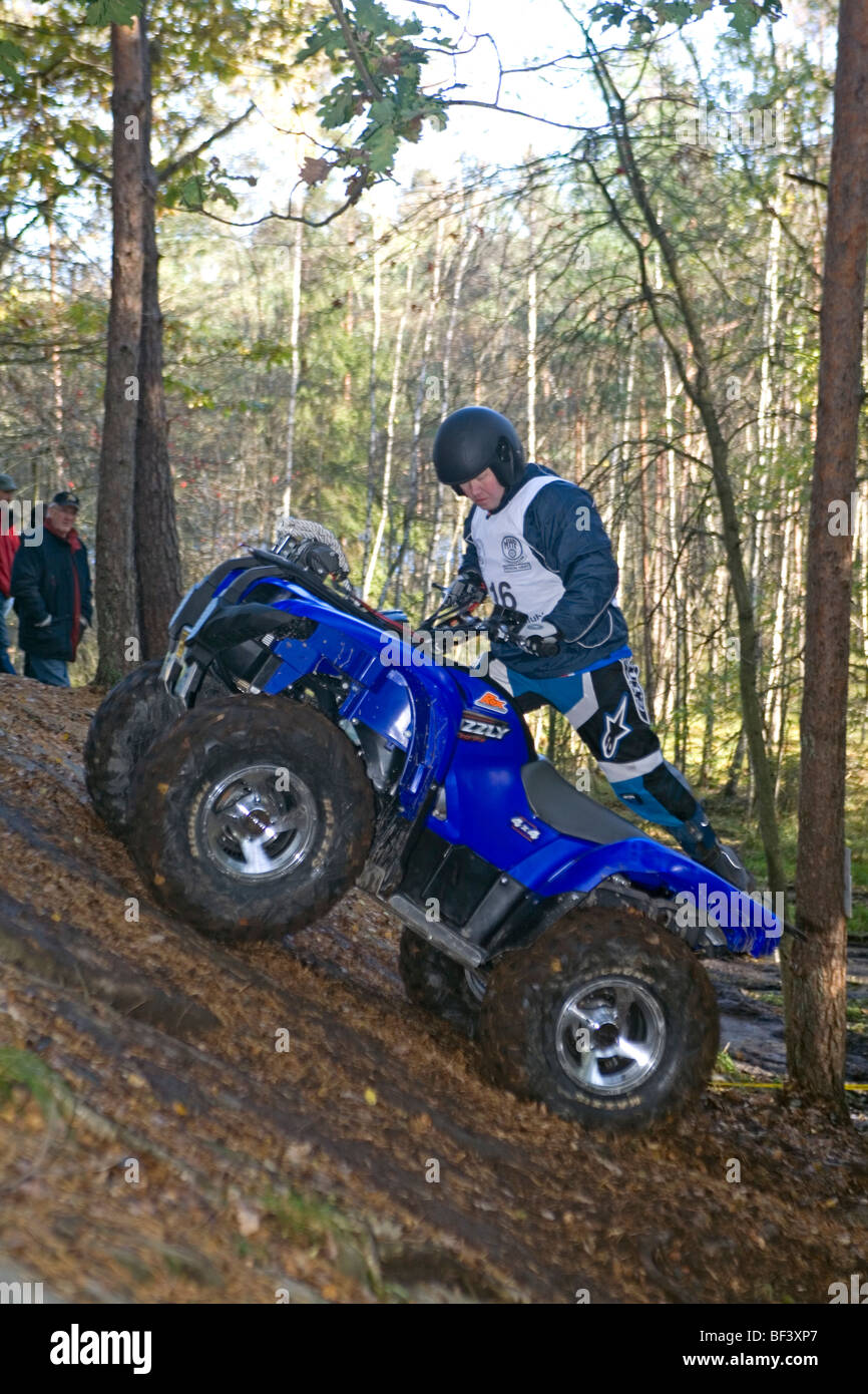 L'uomo corse fuoristrada (ATV) su terreno ripido nel bosco. Trial off-road bike Foto Stock