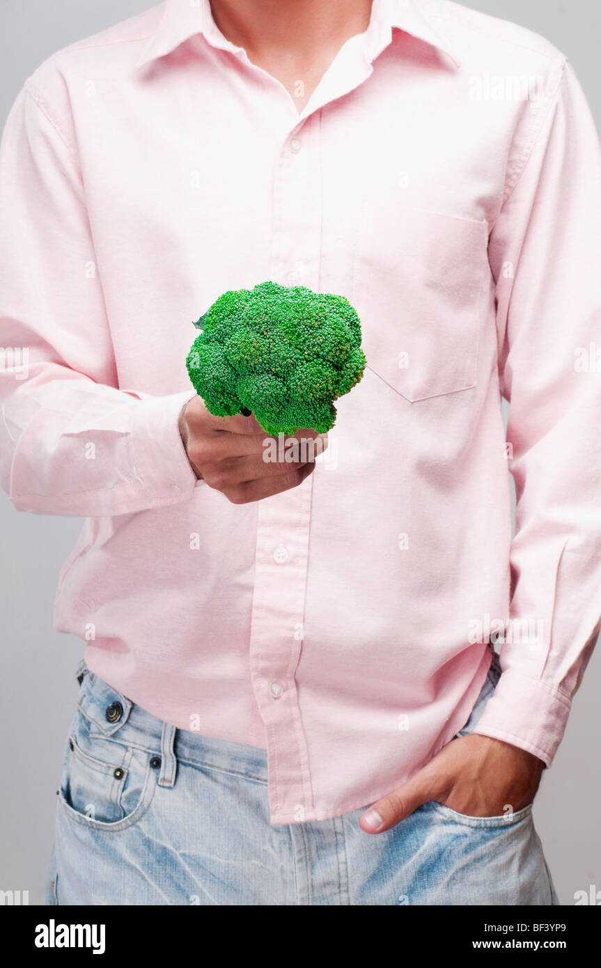 Metà vista in sezione di un uomo in possesso di un broccoli Foto Stock
