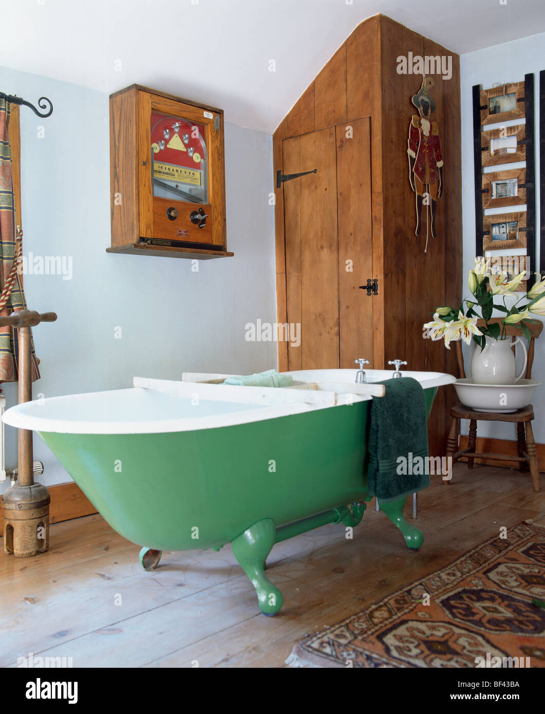 Green roll-top bagno in blu pastello cottage bagno con legno scuro armadio montato e il cabinet Foto Stock