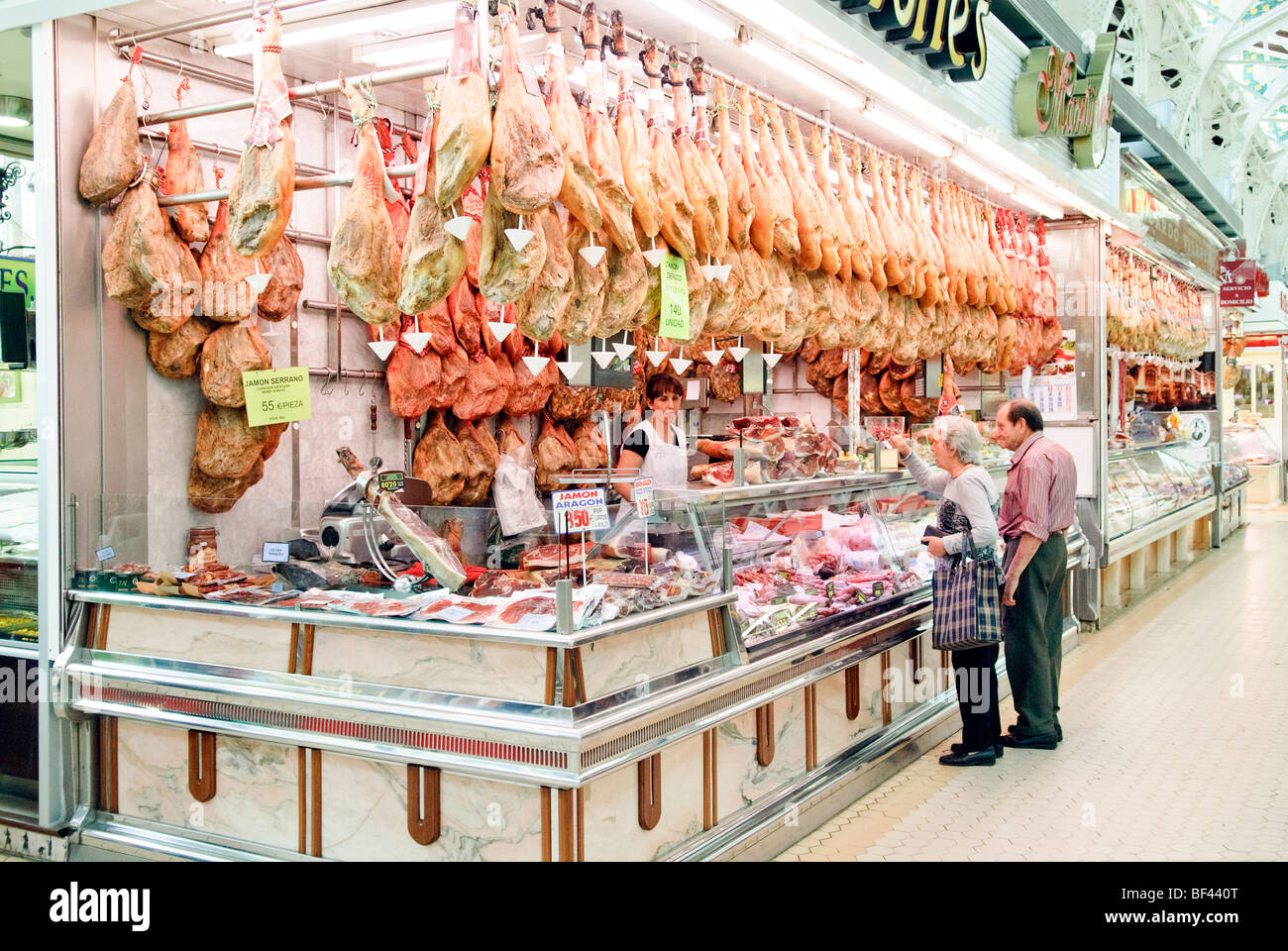 Bancarelle che vendono air cured prosciutti Serrano al Mercado Central, il mercato centrale di Valencia, Spagna Foto Stock