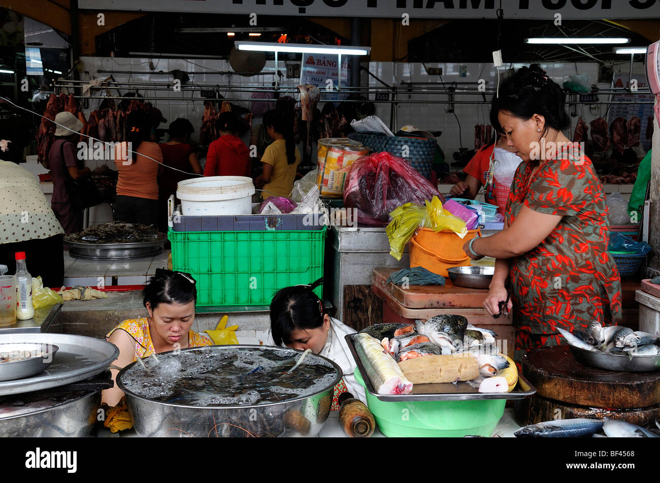 Donna preparare la preparazione di prodotti a base di pesce per la vendita nel mercato aereo aperto di Ho chi minh city Vietnam asia il Mercato Ben Thanh Foto Stock