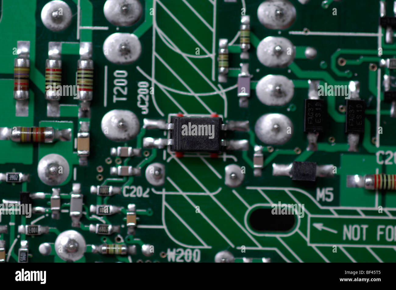 Macro Close-up di elettronica che mostra una a quattro terminali del circuito integrato e numerose resistenze di precisione e di altri dispositivi. Foto Stock