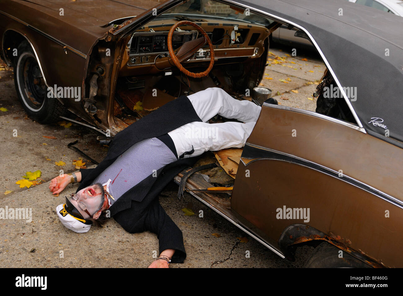 Undead sailor dispiegata su un junked Buick Riviera Auto play agendo al Toronto zombie a piedi Foto Stock