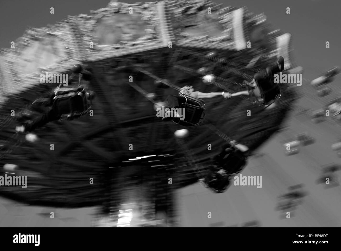 Un giovane tenendo le mani su una fiera a cavalcare in un luna park Foto Stock