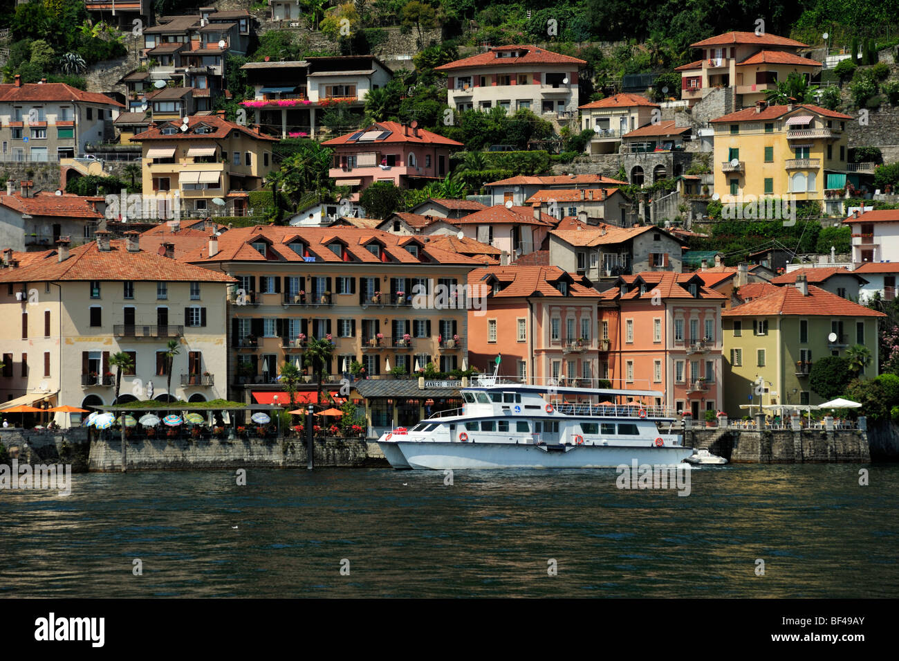 Vista verso una città con un traghetto turistico sul Lago Maggiore, Cannero Riviera, Piemonte, Italia, Europa Foto Stock