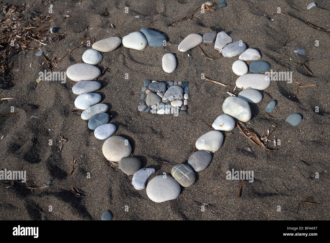 Il simbolo del cuore di fatta di ciottoli sulla spiaggia di roccia aphrodites Petra tou Romiou repubblica di Cipro in Europa Foto Stock