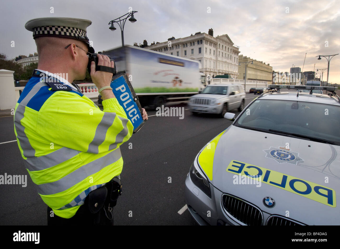 Un funzionario di polizia utilizzando un palmare fotocamera laser su una strada della città per la cattura di velocizzare gli automobilisti Foto Stock