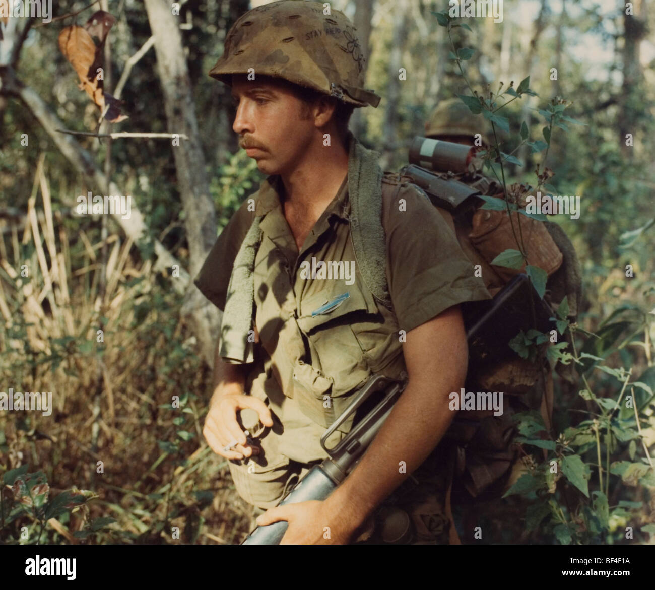 Un membro della prima divisione di cavalleria passeggiate di pattuglia durante il 1968 nella guerra del Vietnam. Foto Stock