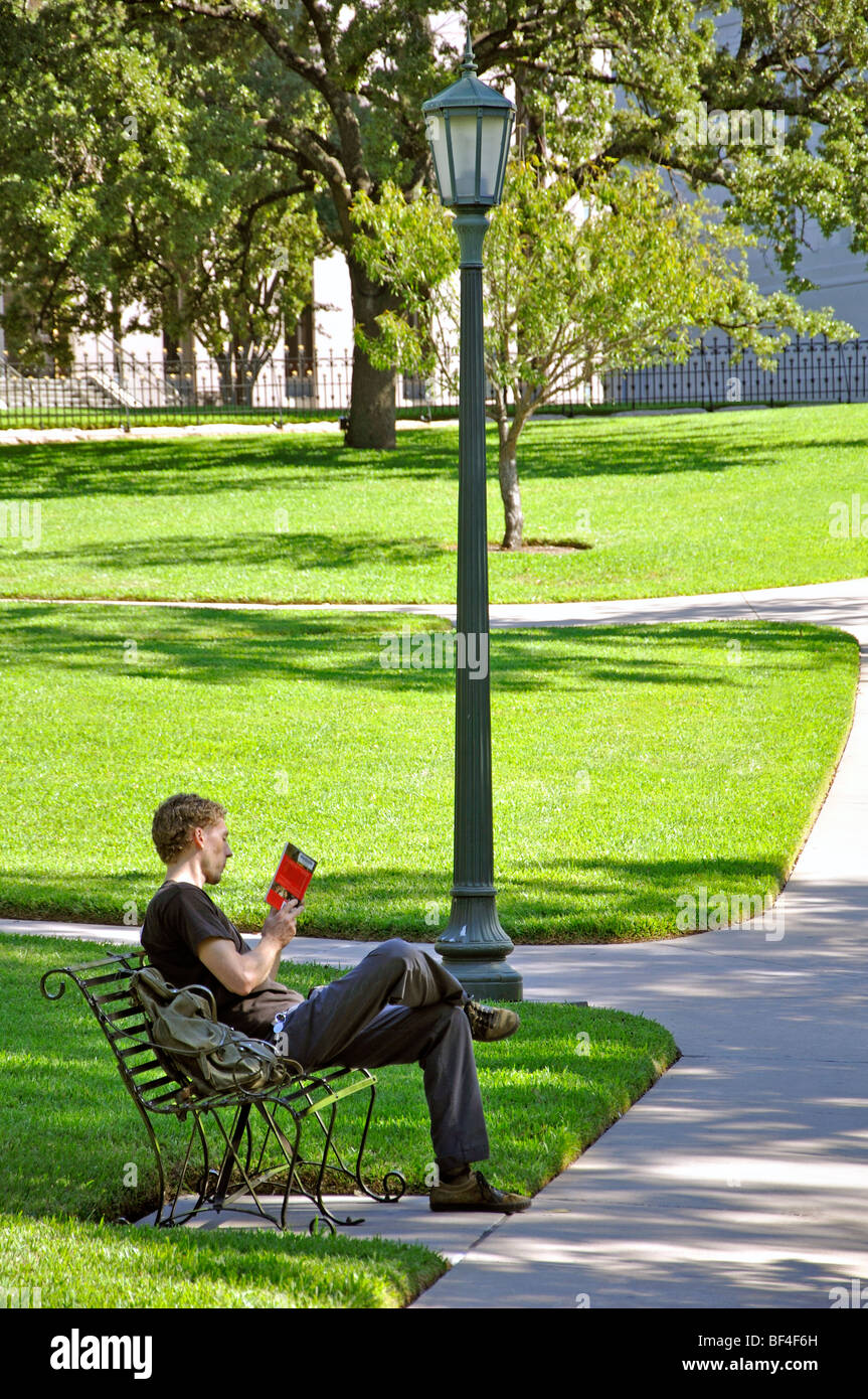 Giovane uomo libro lettura in posizione di parcheggio Foto Stock